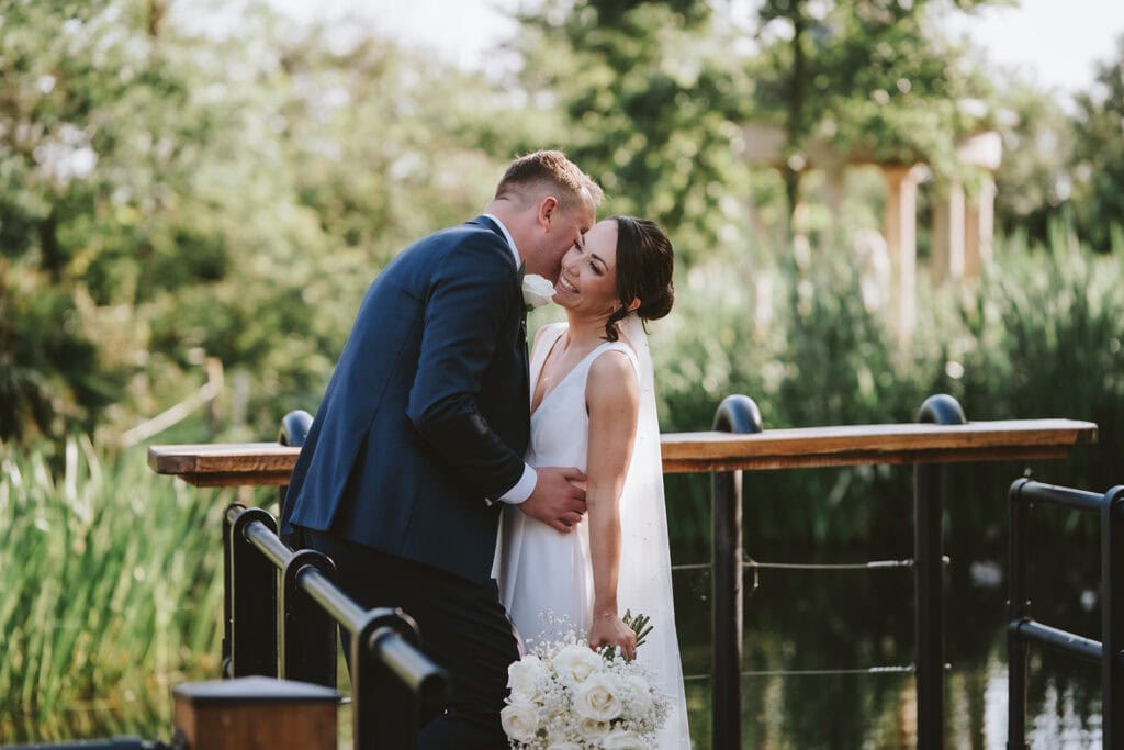 Couple embracing together on the jetty at Friern Manor wedding venue in Brentwood, Essex – natural photography by Lily & White