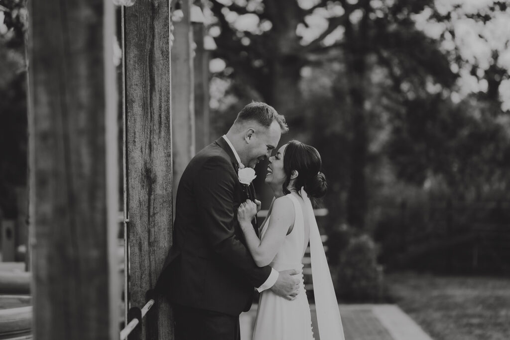 Bride and groom intimate moment in the front garden at Friern Manor country hotel – black and white wedding photography by Lily & White
