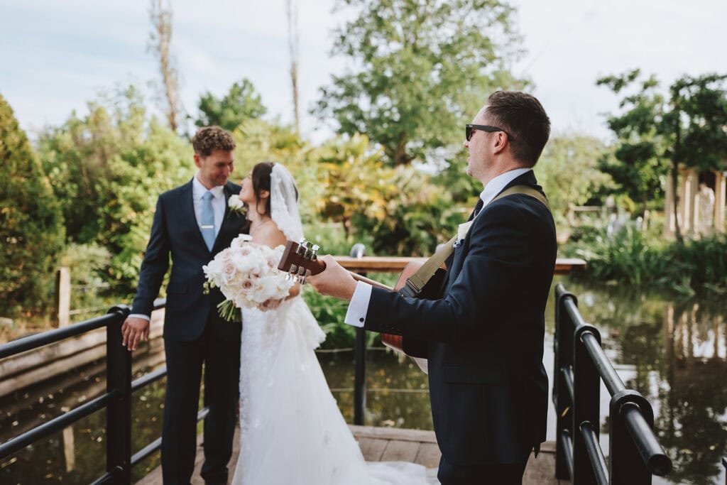 Bride and groom on wooden jetty at Friern Manor gardens – golden hour photography by Lily & White